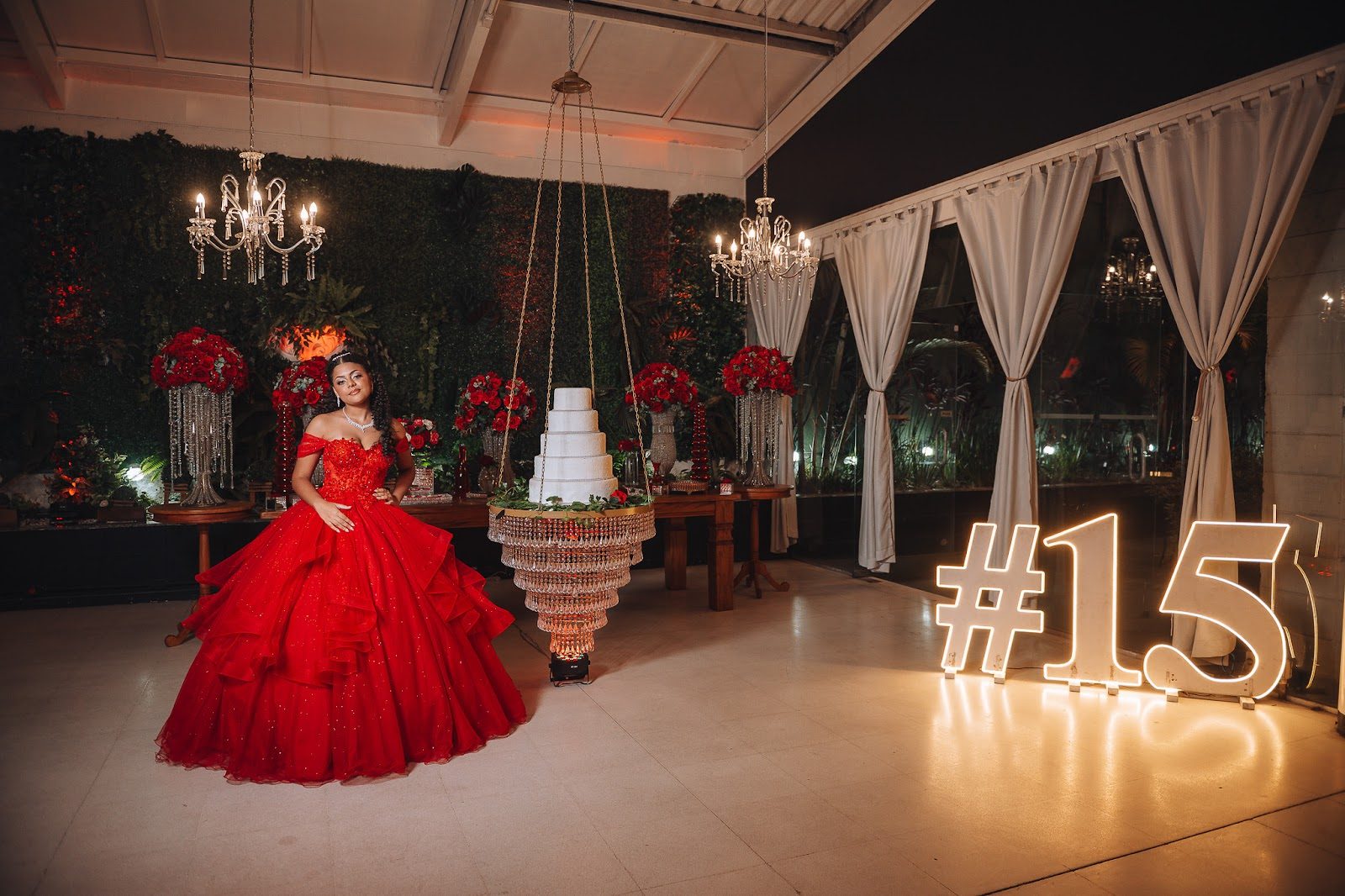Festa de 15 anos no Piatto Buffet com decoração em vermelho, bolo suspenso e muro verde