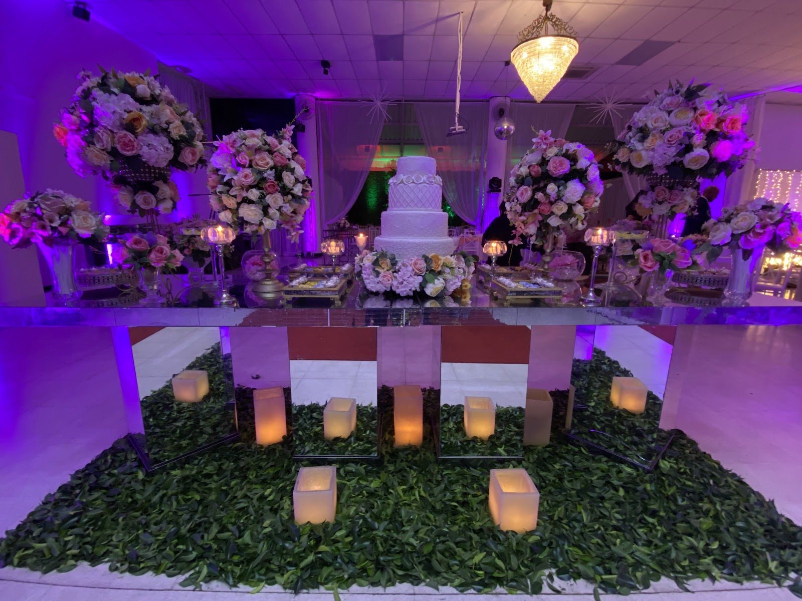 Mesa do bolo de casamento decorada com flores no Piatto Buffet
